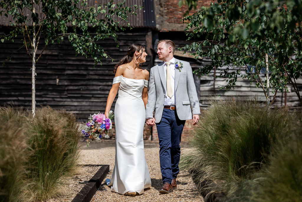 outdoor-wedding-venue-barns-polehanger Wedding couple walking around the grounds at The Gardens at Polehanger